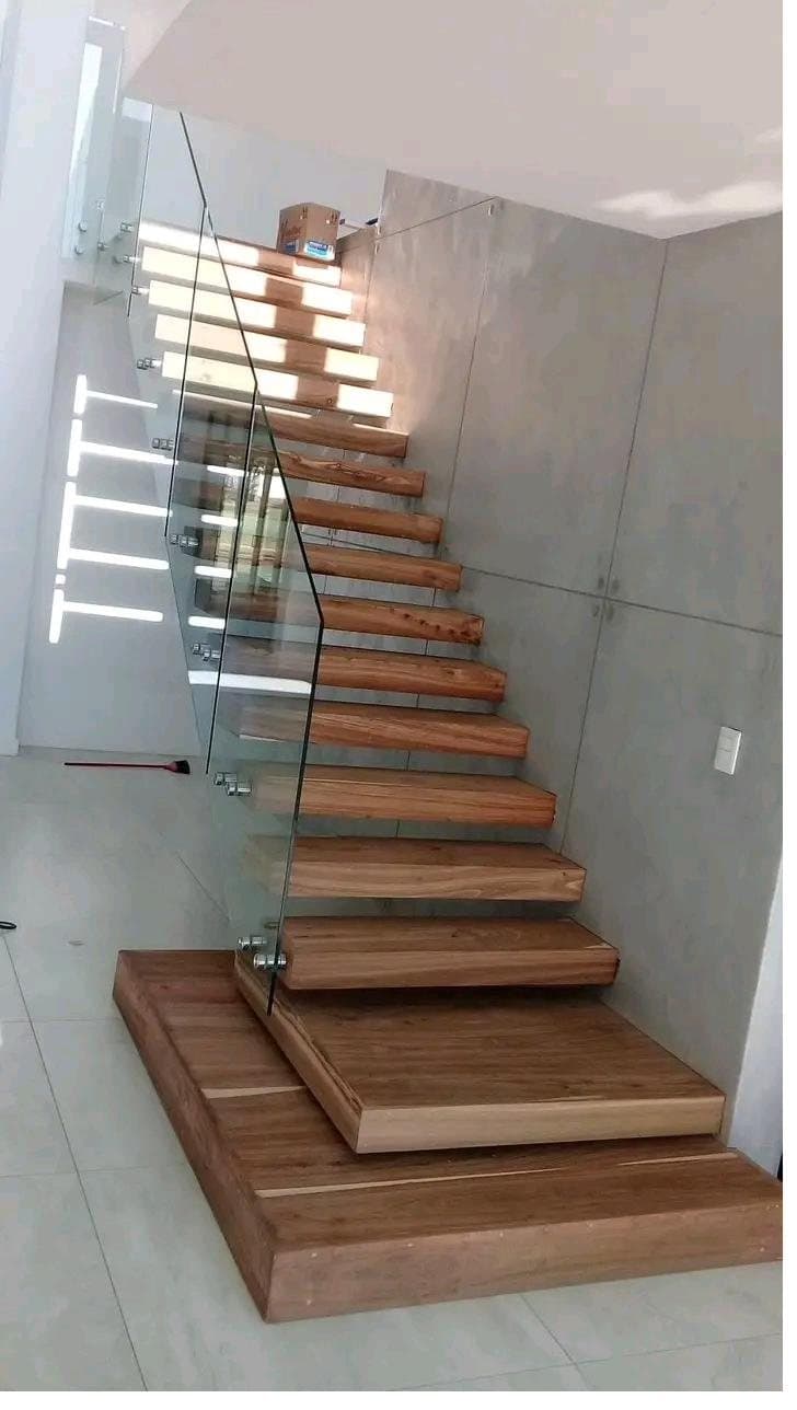 Cantilevered timber staircase with integrated step lighting and a frameless glass balustrade