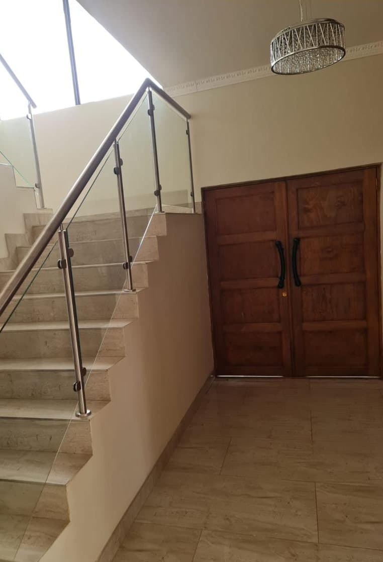 Marble staircase with a glass and brushed steel balustrade in a residential entrance hall