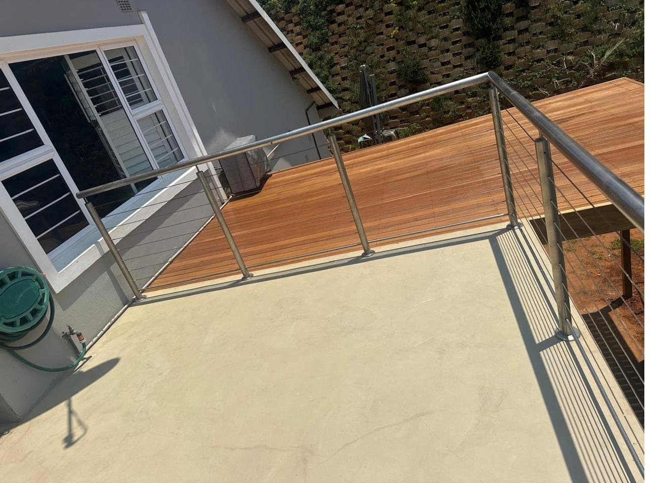Stainless steel cable balustrade along a timber deck overlooking a garden